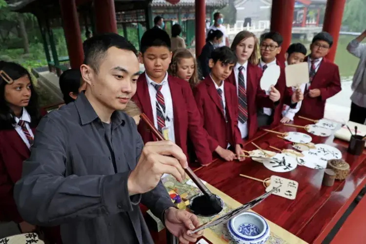 国际学校的学生们在茶文化节的活动上学书法